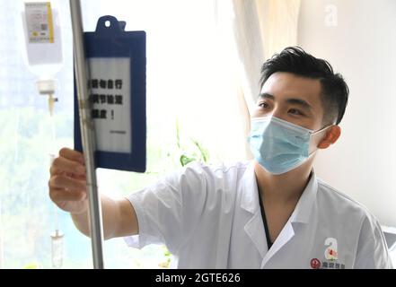 Pékin, Chine. 1er octobre 2021. (211002) -- BEIJING, 2 octobre 2021 (Xinhua) -- Ma Yuan vérifie le registre de traitement d'un patient à l'hôpital Haidian de Beijing, capitale de la Chine, le 1er octobre 2021. Ma Yuan, 28 ans, est chirurgien orthopédique à l'hôpital Haidian de Beijing. Le premier jour de la fête nationale, Ma était occupé comme d'habitude, en ajustant les prescriptions médicales, en admettant et en traitant les patients d'urgence et en rédigeant les dossiers médicaux. En tant que travailleur médical de première ligne, Ma a été utilisé à la vie comme ceci. Bien qu'il ait moins de temps pour accompagner sa famille pendant les vacances, Ma estime que ses efforts sont valeurwhi Banque D'Images
