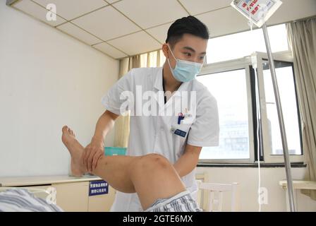 Pékin, Chine. 1er octobre 2021. (211002) -- BEIJING, 2 octobre 2021 (Xinhua) -- Ma Yuan vérifie l'état d'un patient à l'hôpital Haidian de Beijing, capitale de la Chine, le 1er octobre 2021. Ma Yuan, 28 ans, est chirurgien orthopédique à l'hôpital Haidian de Beijing. Le premier jour de la fête nationale, Ma était occupé comme d'habitude, en ajustant les prescriptions médicales, en admettant et en traitant les patients d'urgence et en rédigeant les dossiers médicaux. En tant que travailleur médical de première ligne, Ma a été utilisé à la vie comme ceci. Bien qu'il ait moins de temps pour accompagner sa famille pendant les vacances, Ma estime que ses efforts sont sans valeur Banque D'Images