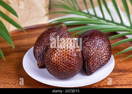 Fruit frais de salak tropical brun mûr sur fond de bois de près Banque D'Images