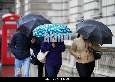 Les gens marchent sous la pluie à Westminster à Londres. Des pluies torrentielles et des vents violents pourraient entraîner des inondations, des perturbations dans les transports et des coupures de courant dans certaines parties de l'Angleterre et de l'Écosse au cours du week-end. Date de la photo: Samedi 2 octobre 2021. Banque D'Images