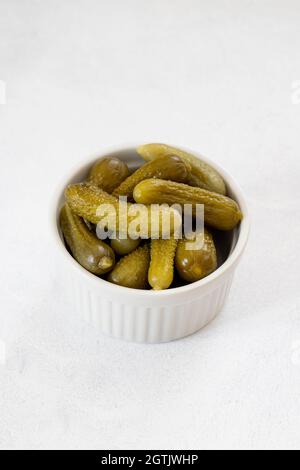 Cornichons croquants dans un bol en céramique blanc.Cornichons verts marinés.Concombre mariné.Délicieux pickles pour bébés.Légumes en conserve savoureux Banque D'Images