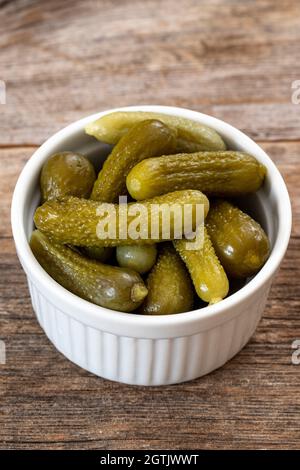 Cornichons croquants dans un bol en céramique blanc.Cornichons verts marinés.Concombre mariné.Délicieux pickles pour bébés.Légumes en conserve savoureux Banque D'Images