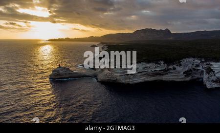 Vue aérienne du phare de la Madonetta à Bonifacio, à l'extrémité sud de l'île de Corse en France - coucher de soleil sur les falaises de calcaire Banque D'Images