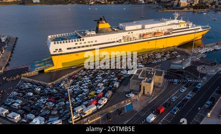 Vue aérienne du phare de l'île de Pietra avec un ferry jaune amarré dans le port de l'Île Rousse en arrière-plan, haute-Corse, France - photo Banque D'Images