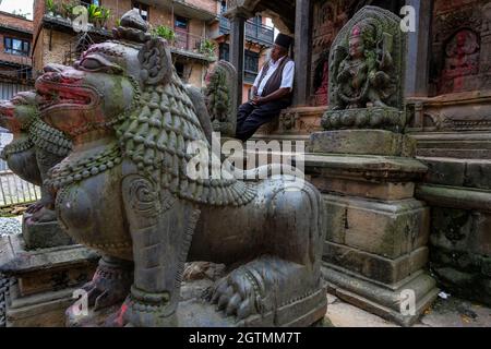 Kirtipur, Népal - octobre 2021 : un homme assis dans un petit temple hindou à Kirtipur le 2 octobre 2021 dans la vallée de Katmandou, au Népal. Banque D'Images