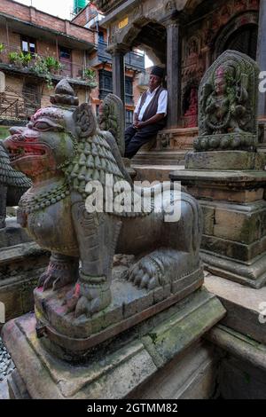 Kirtipur, Népal - octobre 2021 : un homme assis dans un petit temple hindou à Kirtipur le 2 octobre 2021 dans la vallée de Katmandou, au Népal. Banque D'Images