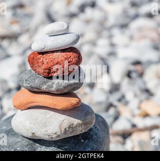 Pierres d'équilibre zen, tour de roche lisse empilée sur fond de plage de galets, jour ensoleillé. Concept d'harmonie et de paix, yoga, thérapie naturelle Banque D'Images