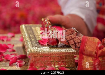 Imaginez une scène vibrante sous un mandap magnifiquement décoré, où le couple heureux est assis côte à côte, rayonnant de joie. La mariée, ornée d'un richement Banque D'Images