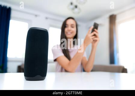 Femme utilisant une enceinte intelligente, un système domestique intelligent, un assistant moderne Banque D'Images