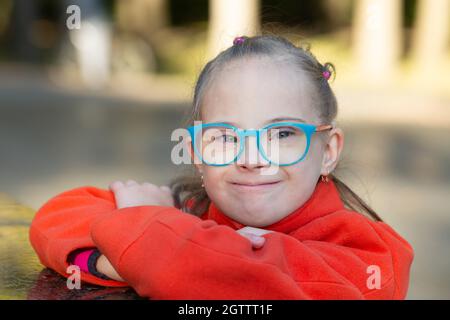 Portrait d'une belle fille avec le syndrome de Down dans un parc d'automne Banque D'Images