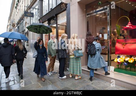 Paris, France, 2 octobre 2021 : la pluie à Paris n'empêche pas les gens de faire du shopping dans la rue St Honoré, de s'asseoir à l'extérieur des cafés, de poser avec les colonnes de Buren au Palais Royal ou même de prendre leurs photos de mariage. Anna Watson/Alay Live News Banque D'Images