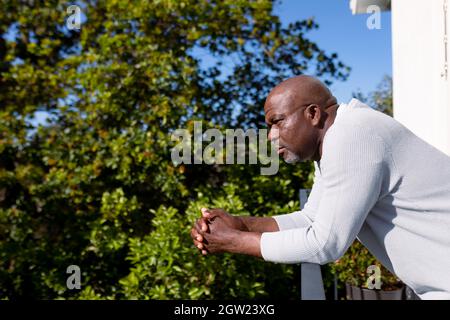 Vue latérale d'un homme senior afro-américain sur un balcon qui donne sur la distance Banque D'Images