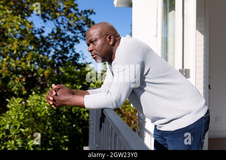 Vue latérale d'un homme senior afro-américain sur un balcon qui donne sur la distance Banque D'Images
