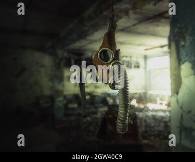 Masque à gaz suspendu dans un bâtiment abandonné - Pripyat, zone d'exclusion de Tchernobyl, Ukraine Banque D'Images