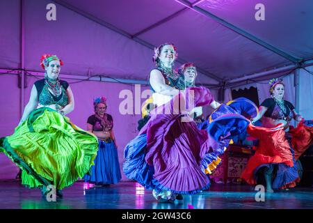 Danseuses du ventre en costumes tziganes, leurs jupes volant comme ils se produisent sur scène Banque D'Images