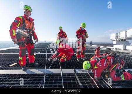 29 septembre 2021, Hessen, Francfort-sur-le-main: Les pompiers de l'équipe de sauvetage en hauteur de la brigade des pompiers de Francfort se préparent pour un rappel sur le toit de la tour Winx. La moindre erreur peut être la chute des sauveteurs de hauteur lors de leurs missions sur les gratte-ciels de la métropole bancaire. (À dpa « High up - height resevers in action in Extreme situations ») photo : Boris Roessler/dpa Banque D'Images