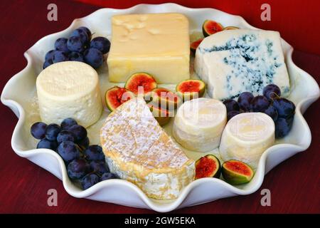 Plateau de fromages avec camembert, fromage de chèvre, fromage bleu, figues fraîches et raisins Banque D'Images