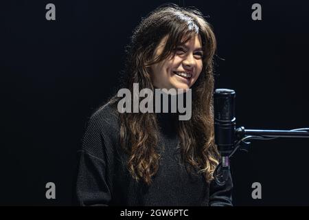 Une jeune fille souriante, en train d'enregistrer un podcast en studio, en enregistrant la voix dans un concept professionnel de microphone, de radio ou d'enregistrement vidéo. Banque D'Images