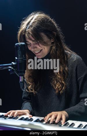 Fille gaie dans le processus d'enregistrement de contenu musical dans le studio, l'enregistrement de la voix dans un microphone professionnel, le concept d'apprentissage du piano Banque D'Images