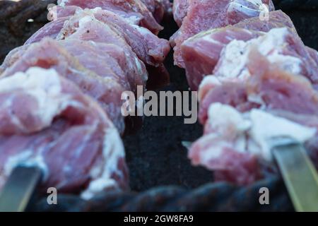 Gros plan de deux brochettes avec du fromage et de la viande marinée sur le gril. Mise au point sélective. Le concept de la cuisine dans l'arrière-cour Banque D'Images