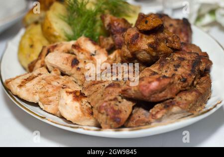 Viande frite, barbecue juteux en grands morceaux posés sur une assiette avec des légumes dans un restaurant Banque D'Images