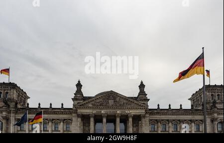 Berlin, Allemagne. 03ème octobre 2021. Les drapeaux allemands sont vus au Reichstag le jour de l'unité allemande. La loi allemande sur la Journée de l'unité est entrée en vigueur le 4 août 1953. À l'avenir, le 17 juin devait servir de jour commémoratif national officiel pour commémorer le soulèvement de 1953 dans la RDA. Depuis la réunification allemande en 1990, la « Journée de l'unité allemande » a été célébrée le 3 octobre. Credit: Paul Zinken/dpa/Alay Live News Banque D'Images