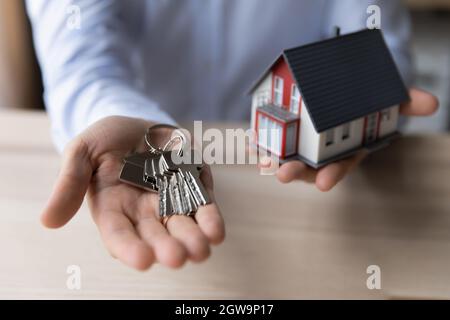 Récolte gros plan homme immobilier tenant les clés et modèle de maison Banque D'Images