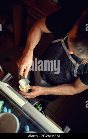 versez du lait chaud dans une tasse de cappuccino. un café professionnel Banque D'Images