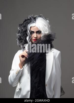 Une beauté fatale dans une image de mode audacieuse avec des cheveux noirs et blancs. Une image de style rebelle pour Halloween. Banque D'Images