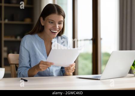 Choqué bonne étudiante fille recevant la lettre d'admission de l'université Banque D'Images