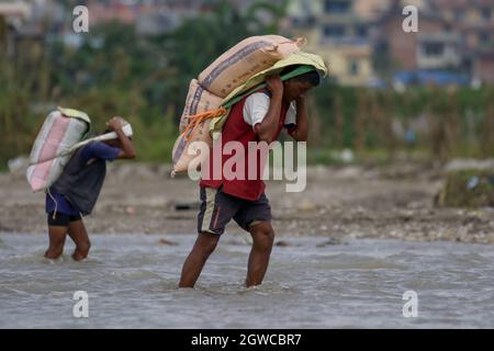 3 octobre 2021, Katmandou, ne, Népal: Deux hommes portent un sac de sable sur un chantier de construction, de l'autre côté de la rivière Manohara, à Katmandou, au Népal, le 3 octobre 2021. (Image de crédit : © Aryan Dhimal/ZUMA Press Wire) Banque D'Images