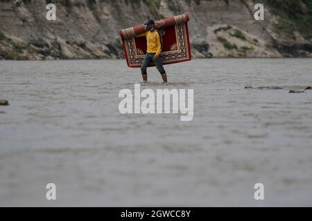 3 octobre 2021, Katmandou, ne, Népal: Un vendeur porte des tapis alors qu'il traverse la rivière Manohara à Katmandou, Népal, le 3 octobre 2021. (Image de crédit : © Aryan Dhimal/ZUMA Press Wire) Banque D'Images