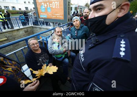 Un policier tente de détenir une femme pour avoir tenu un panneau indiquant « vous assassiner des personnes » à Varsovie, en Pologne, le 01 octobre 2021. Une centaine de personnes se sont ralliées devant le siège des gardes-frontières polonais pour protester contre la pratique des actions de rappel. Depuis le début de l'été, des milliers de migrants, principalement originaires d'Iraq, ont été forcés de passer la frontière entre le Bélarus et la Pologne et les pays baltes. La Pologne a réagi en repoussant les migraines vers le Belarus, une pratique qui défit clairement les réglementations interinternationales et la législation de l’UE. (Photo de Jaap Arriens / Sipa USA) Banque D'Images