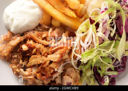 Viande de poulet au kebab rôti avec frites, salade et sauce tzatziki, vue en grand angle depuis le dessus, gros plan plein format, mise au point sélectionnée, narr Banque D'Images