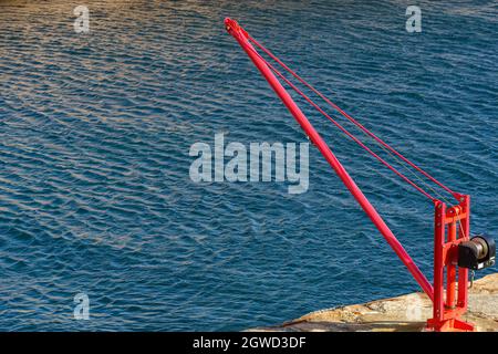 LINDESNES, NORVÈGE- SEPTEMBRE 08. Ancienne grue en fer rouge pour soulever des bateaux à coque au phare de Lindesnes. Banque D'Images