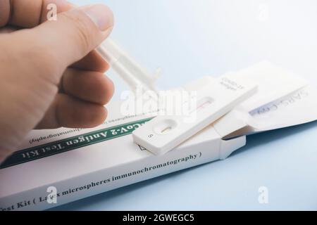 À la main, placez l'échantillon de sécrétions dans le kit de test rapide d'antigène (ATK) du COV-2 du SRAS avec le tube d'extraction, le coronavirus infectieux de protection con Banque D'Images