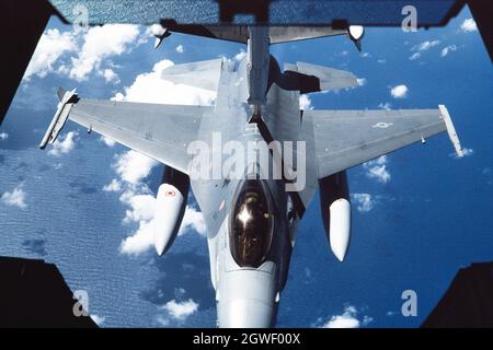 Un chasseur F-16 de la U.S. Air Force est ravitaillé par un camion-citerne KC-10 Extender au-dessus de l'océan Pacifique. Banque D'Images