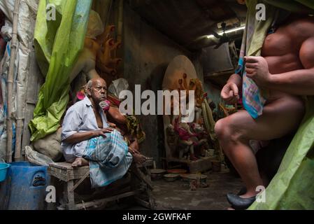 Comme Durga Puja est au coin de la rue, un vieil homme inquiet dans son atelier avec des idoles incomplètes. Banque D'Images