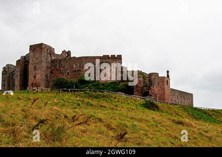 Le château de Bamburgh, situé sur une colline, a été construit autour d'un donjon normand du XIe siècle par Henry ll et restauré au XIXe siècle par Lord Armstrong Banque D'Images