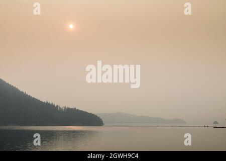 Lever du soleil à travers le brouillard, Hungry Horse Reservoir, Flathead National Forest, Montana, États-Unis Banque D'Images