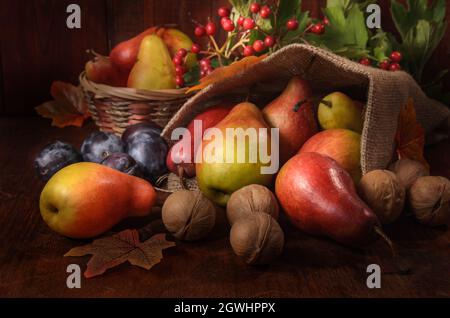 poires, prunes et autres baies et fruits en vrac sur fond de bois sombre dans un style rustique Banque D'Images