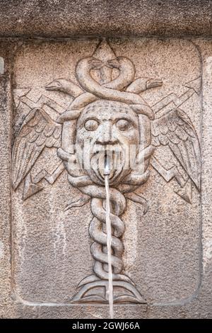 Gros plan d'une ancienne fontaine avec une sculpture de caduceus Banque D'Images