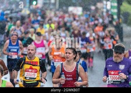 Tower Hill, Londres, Royaume-Uni. 3 octobre 2021. De fortes pluies ont frappé tard dans le marathon de Londres Virgin Money 2021 alors que les coureurs de plaisir passaient par Tower Hill. Banque D'Images