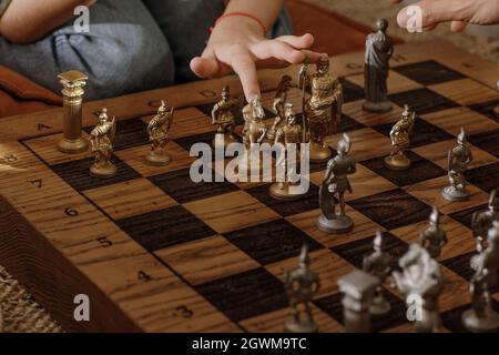 Jeu d'échecs romains en métal ancien avec pièces plaquées argent et or sur une planche en chêne massif. Image de concept pour la stratégie d'affaires, la concurrence, la détente Banque D'Images