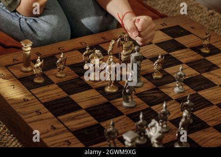 Jeu d'échecs romains en métal ancien avec pièces plaquées argent et or sur une planche en chêne massif. Image de concept pour la stratégie d'affaires, la concurrence, la détente Banque D'Images