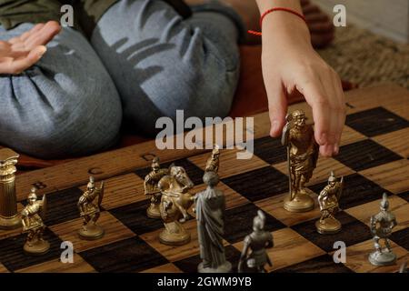 Jeu d'échecs romains en métal ancien avec pièces plaquées argent et or sur une planche en chêne massif. Image de concept pour la stratégie d'affaires, la concurrence, la détente Banque D'Images