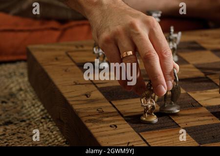 Jeu d'échecs romains en métal ancien avec pièces plaquées argent et or sur une planche en chêne massif. Image de concept pour la stratégie d'affaires, la concurrence, la détente Banque D'Images