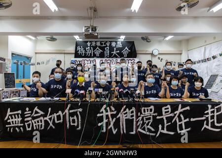 Hong Kong, Hong Kong. 03ème octobre 2021. Les membres du Comité tiennent la main alors qu'ils posent pour une dernière photo derrière une bannière qui se lit "quoi que ce soit, nous sommes encore unis." sous la répression politique, le plus grand syndicat d'opposition de Hong Kong, La Confédération des syndicats de Hong Kong (HKCTU) a aujourd'hui une réunion spéciale et a voté le vote de débridage comme 57 votes d'accord, 8 s'opposent et 2 blancs, mettant fin à ses 31 années de service depuis 1990, après un balayage sur l'élimination de toute dissidence des responsables chinois dans la ville. (Photo par TSZ Yuk Alex Chan/SOPA Images/Sipa USA) crédit: SIPA USA/Alay Live News Banque D'Images