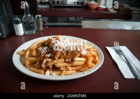 Une assiette de poutine grecque au fromage feta, un plat canadien emblématique, servie dans un restaurant traditionnel à Toronto, Canada. Banque D'Images