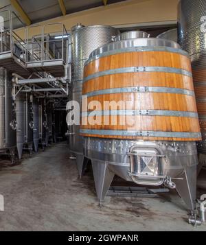 Cuve de fermentation de vin en bois de chêne. Cuves en acier pour la fermentation du vin dans une usine de vinification. Cuves à vin en bois de chêne dans une rangée à l'intérieur de la cave. Banque D'Images